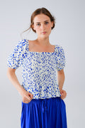 Q2 Blusa blanca con pliegues y lunares azules