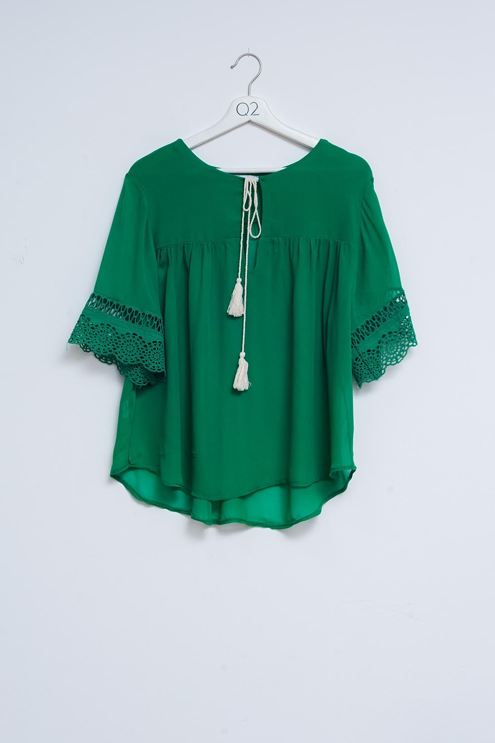 Q2 Blusa verde con lazadas en la parte delantera y bordados